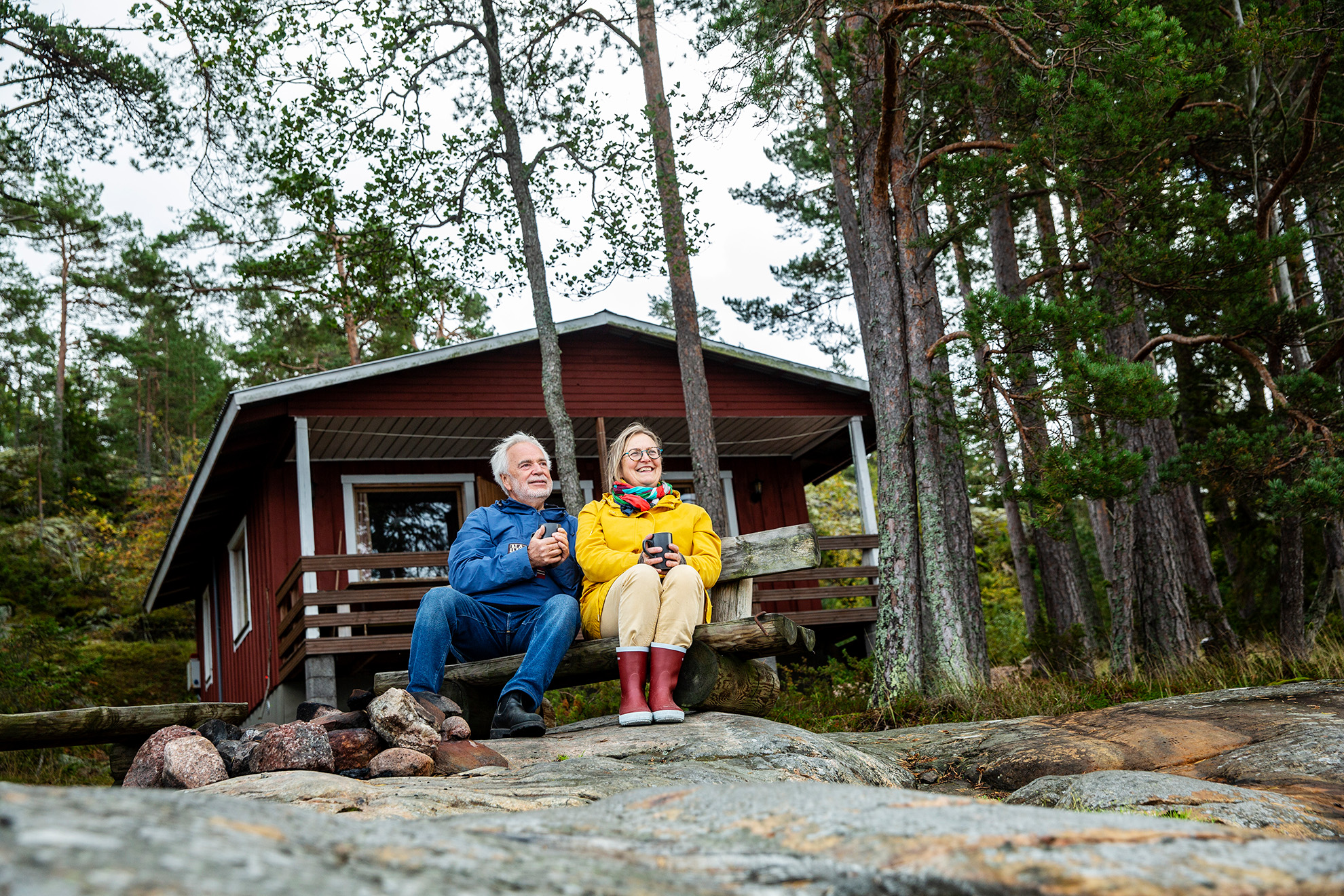 People sitting in front of a cabin at the island Houtskär in the Finnish archipelago