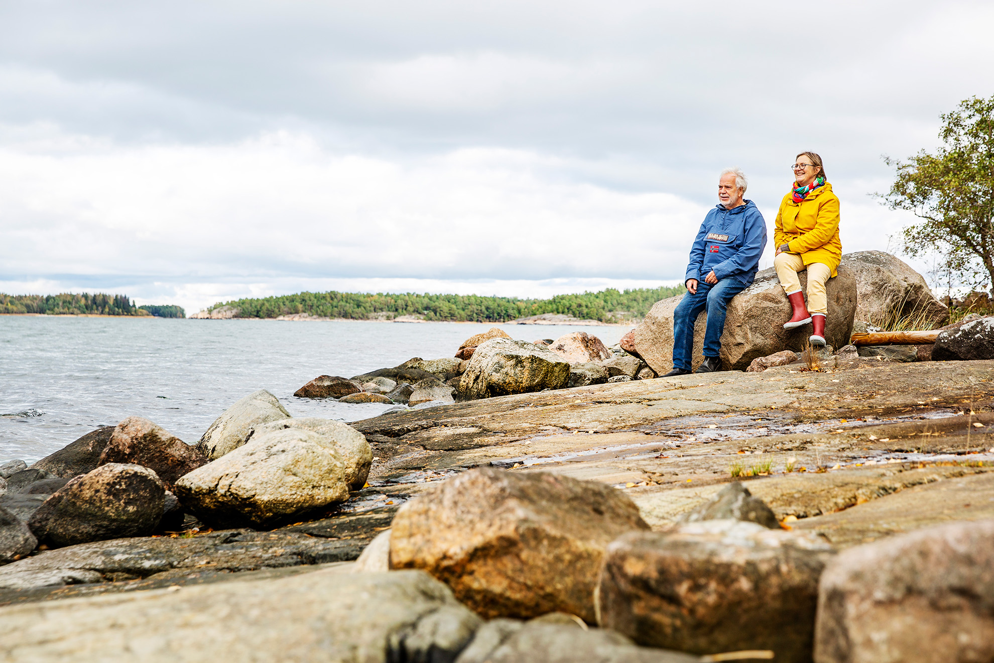 People sitting watching the sea at the island Houtskär in the Finnish archipelago