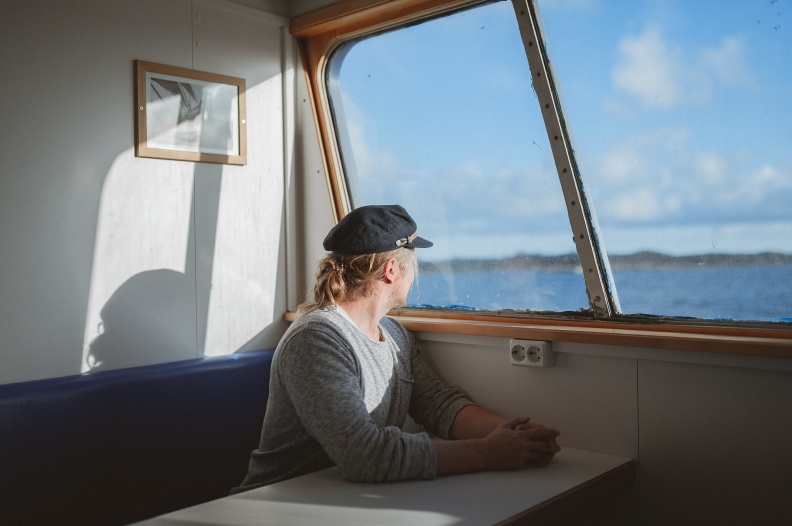 A person looking out of the window on the ferryboat to Utö island in the Finnish archipelago