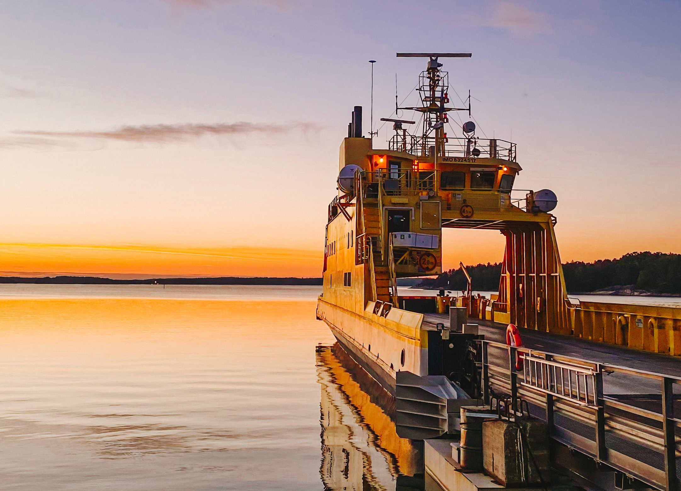 Yellow car ferry during sunset in the Finnish archipelago